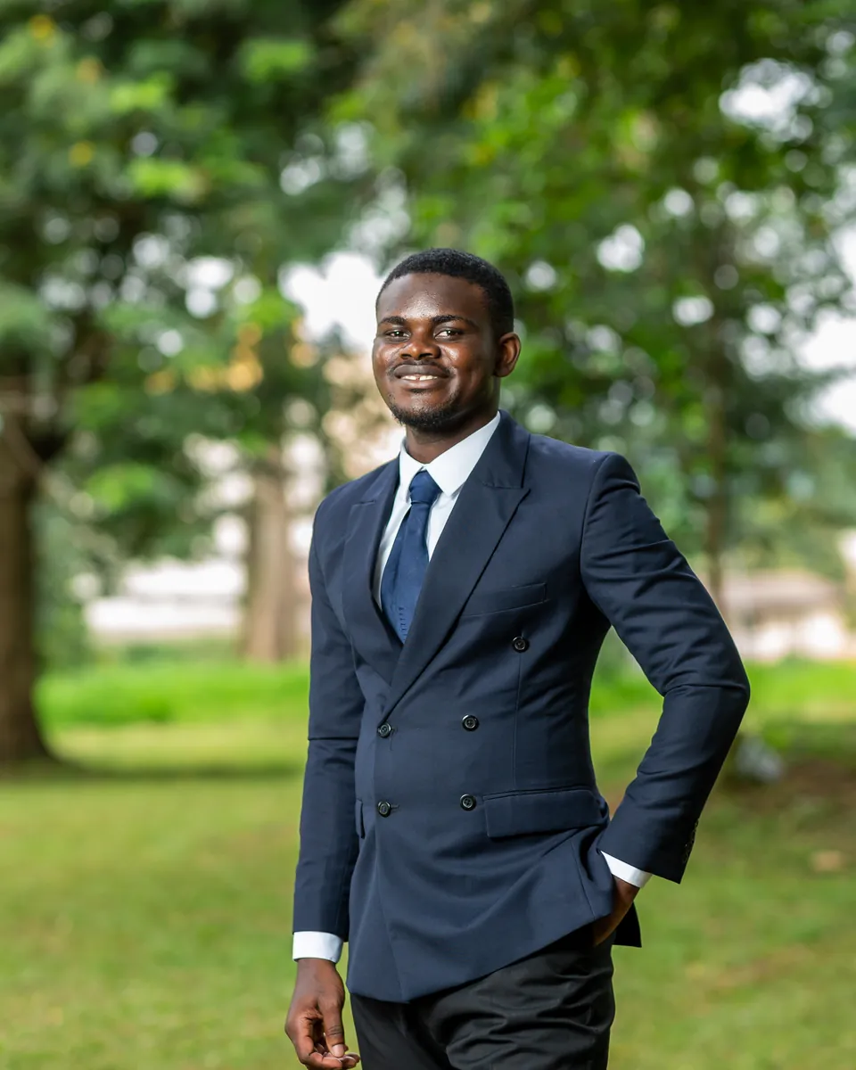 Nicholas Osei Kofi Asare, founder of N.O.K Social, smiling outdoors in a navy suit